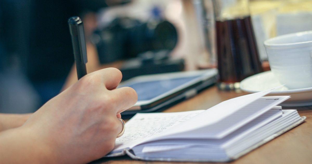 编辑部工作台上摊开的笔记与屏幕截图，编辑正在逐条核对 ghub 相关公开资料并标注来源链接